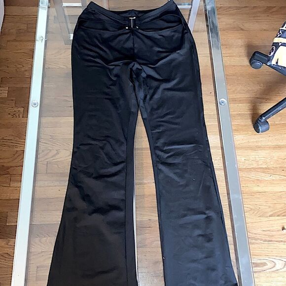 Put on black flare pants with cut out waste accent and silver accessory. Stretch - Picture 3 of 11